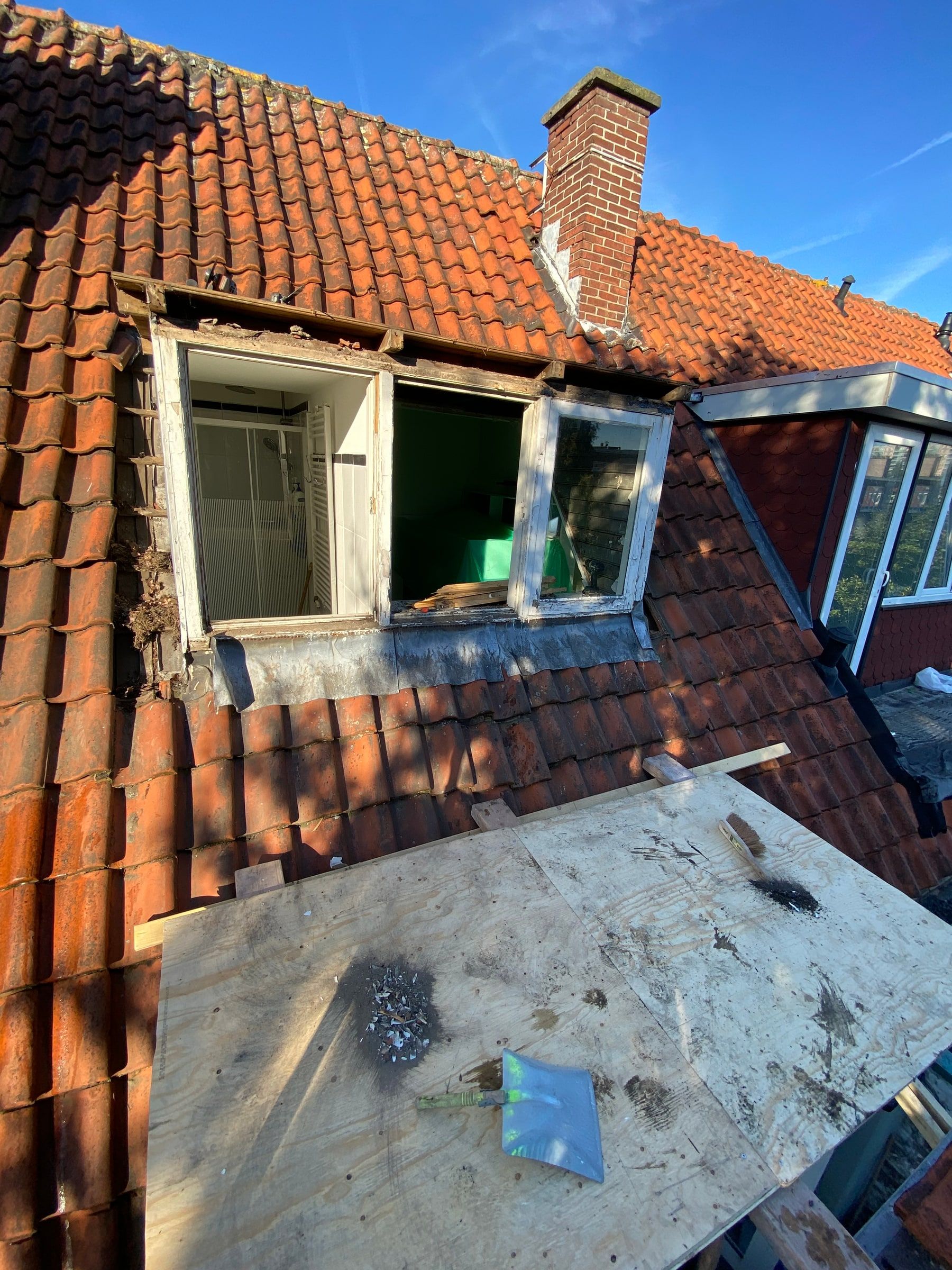 De oude dakkapel opengebroken, klaar om vervangen te worden