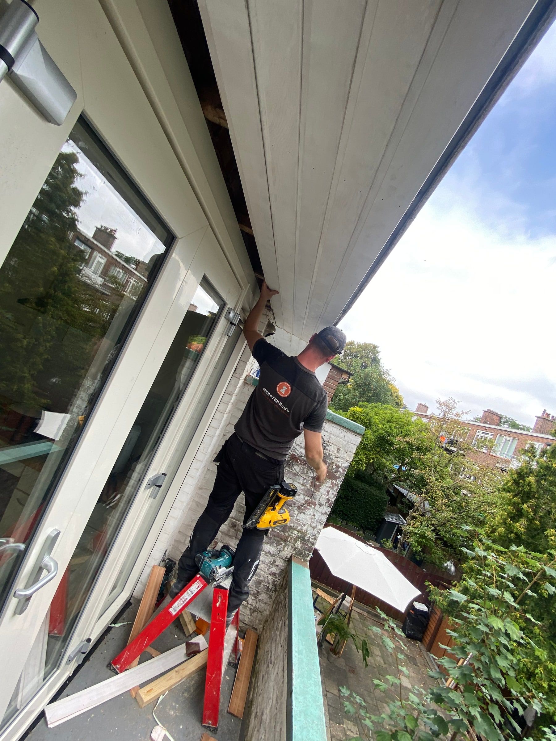 Nieuw boeiboord wordt gemonteerd onder het dakoverstek bij een balkon