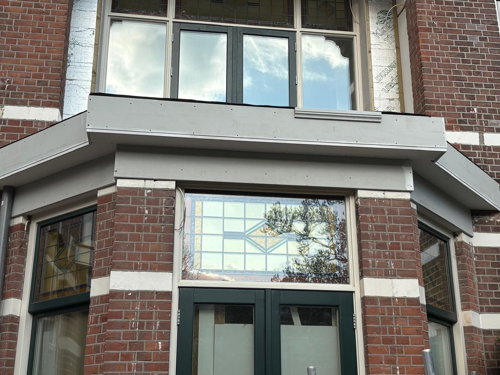 Afgewerkte erker met nieuw dakrand- en boeiboordwerk in de gevel