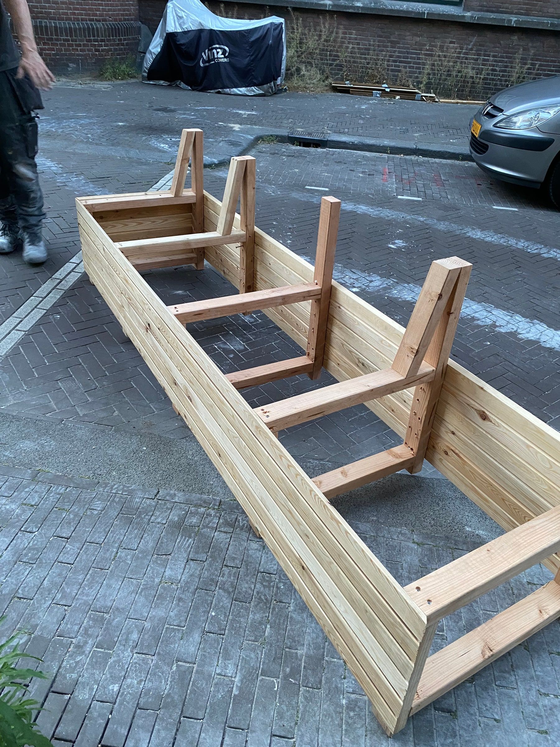 Houten frame voor een plantenbak op maat, opgebouwd op straat